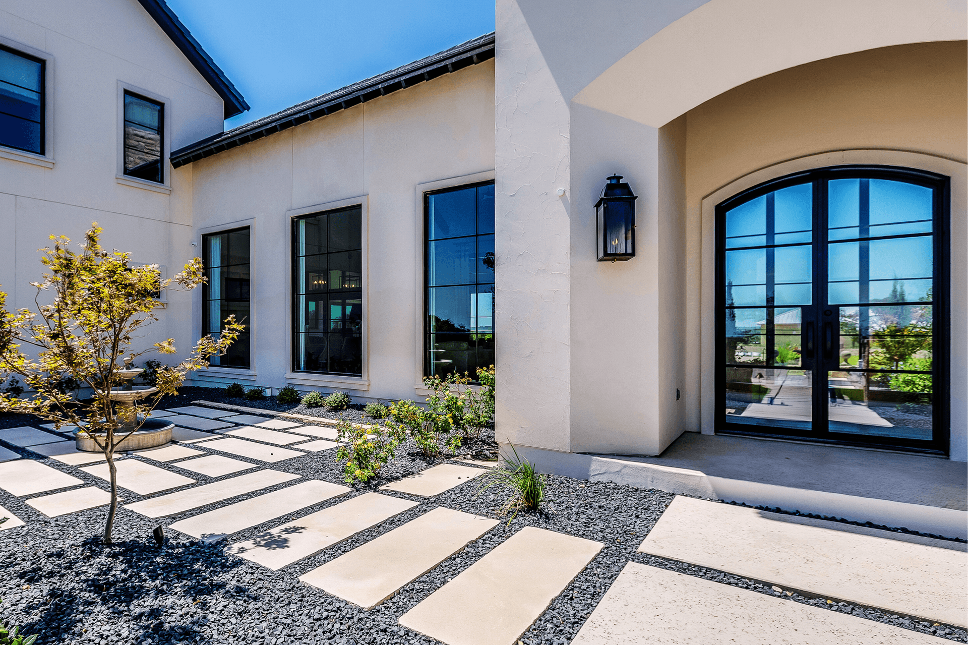 stucco home with glass windows and front entry door