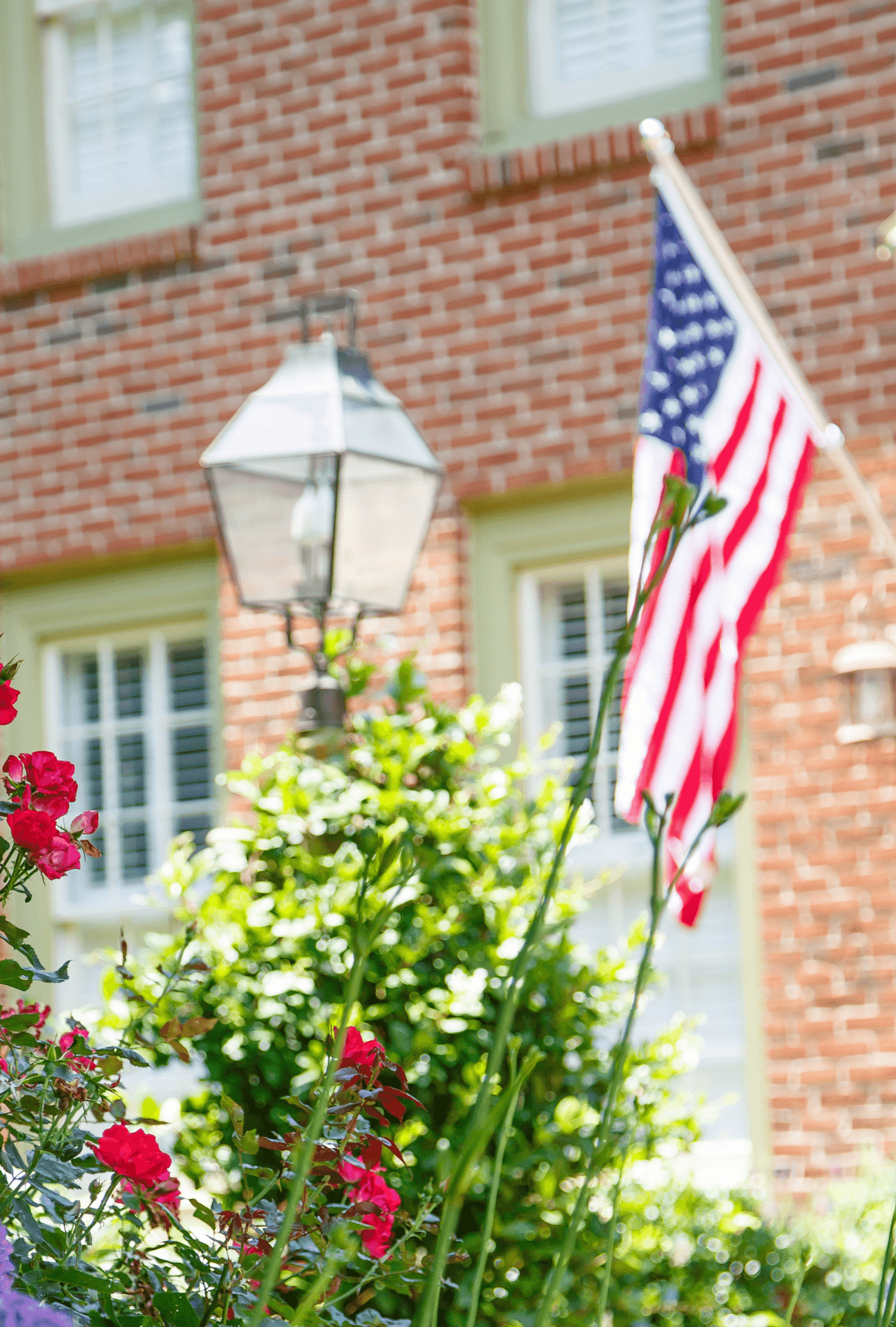 American flags flows in front of beautiful Georgian style home