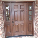 A beautiful brown door on a brick home.