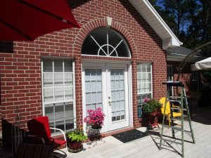 A home with brick walls and large aluminum windows with white trim