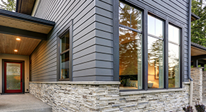 An outdoor view of a home featuring large, clear aluminum windows.
