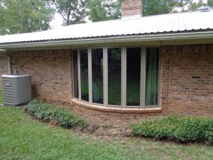 An outdoor view of vinyl bow windows on a beautiful brick home.