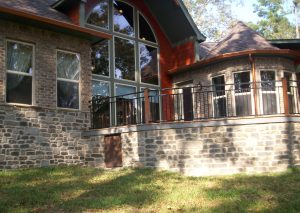 Fancy brick home with many windows facing shaded backyard