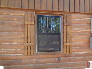 Close up of single-hung aluminum window on log cabin home